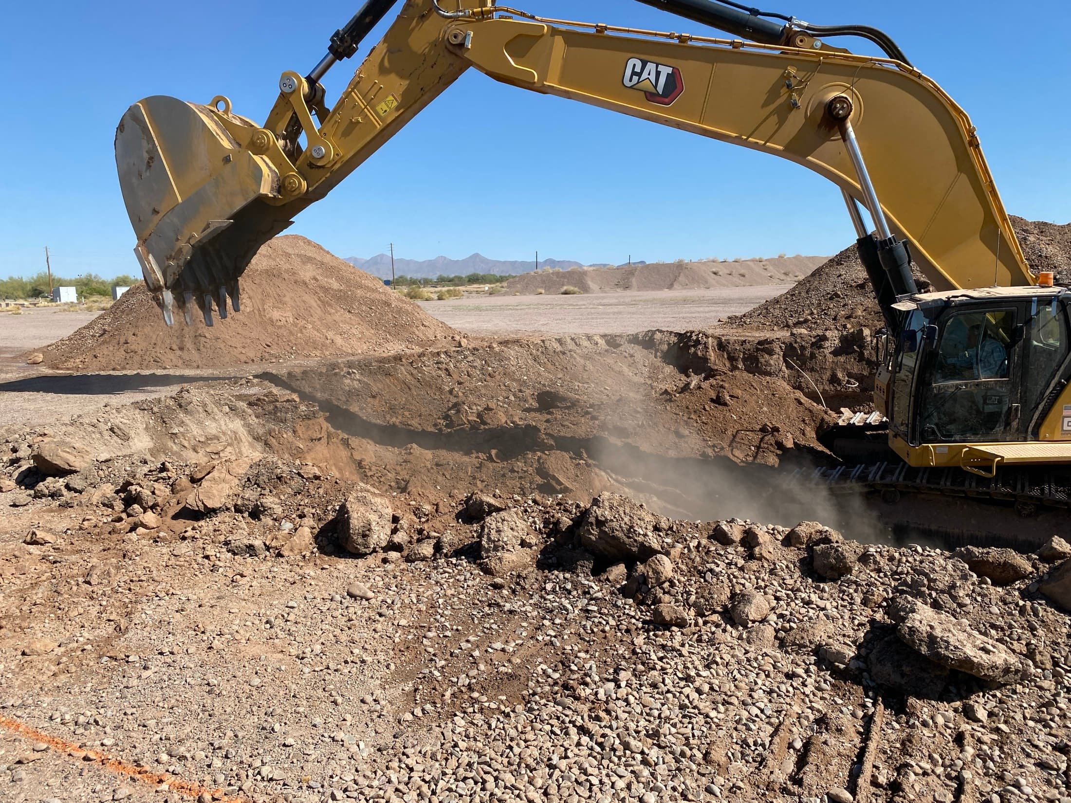 Excavator cutting into compacted ground on a plant expansion