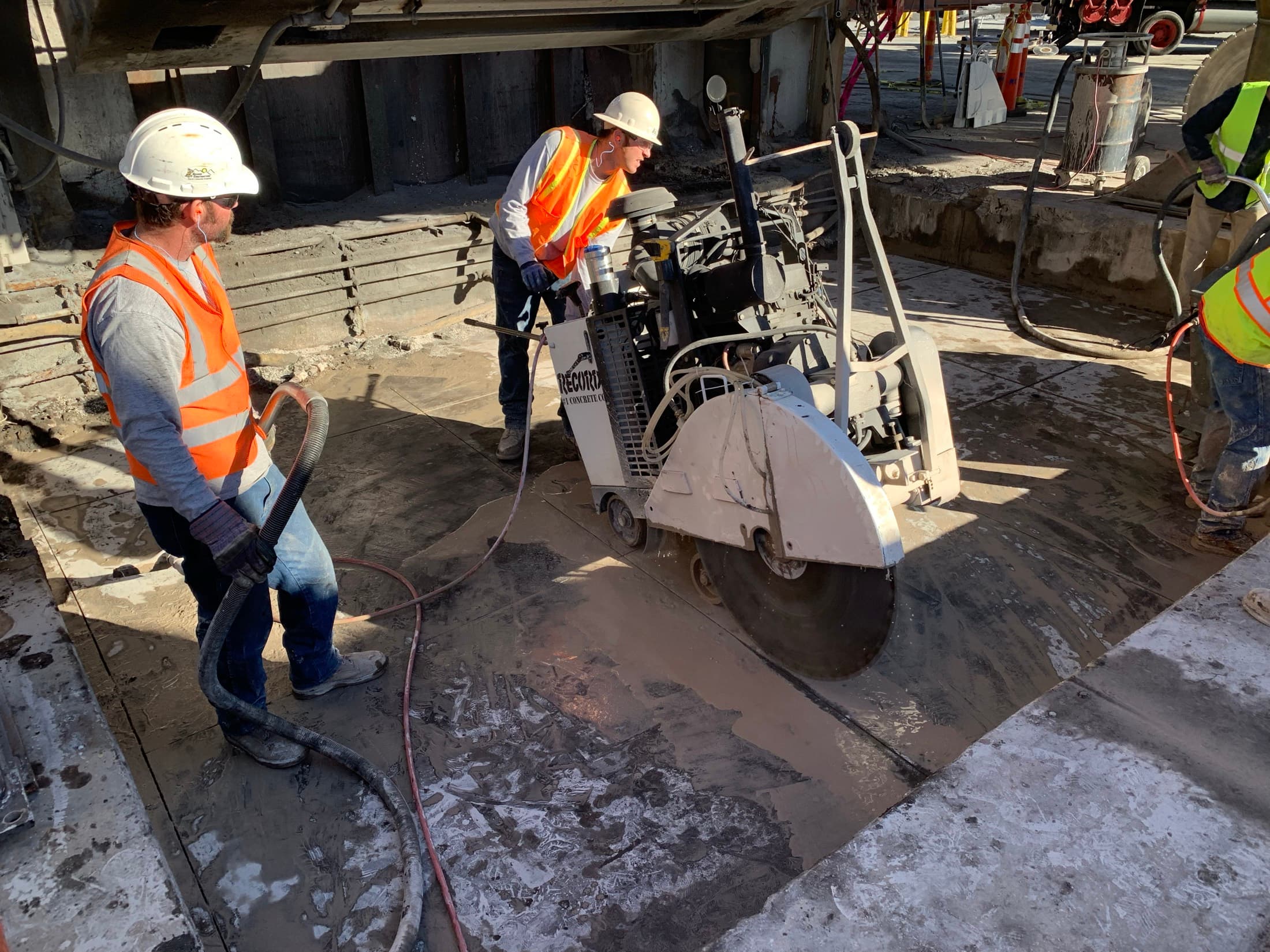 Crew saw cutting a foundation directly beneath a suspended furnace